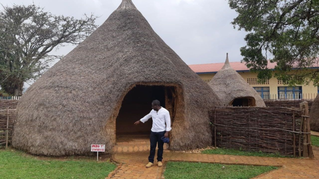 Casa rústica de palha com pessoa na entrada